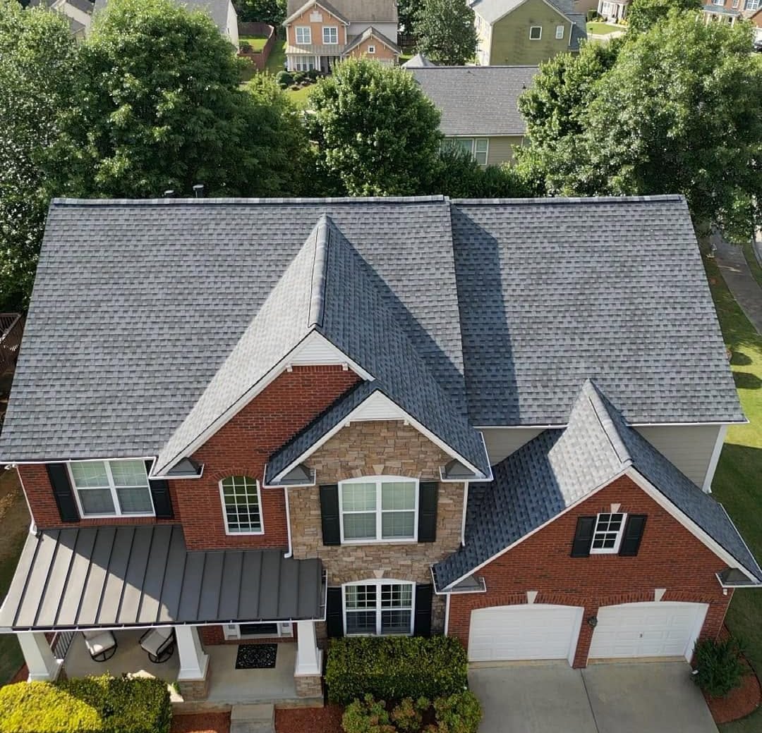 Brick home with a new gray shingle roof, after replacement