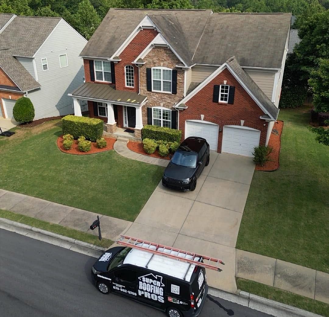 The same brick home with an old, stained roof, before replacement