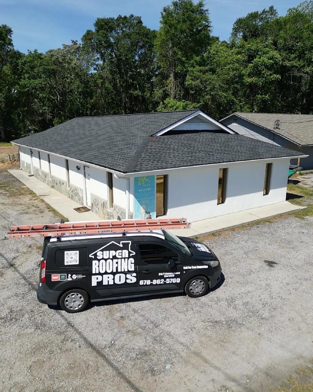 Super Roofing Pros van parked at a commercial building with a new roof